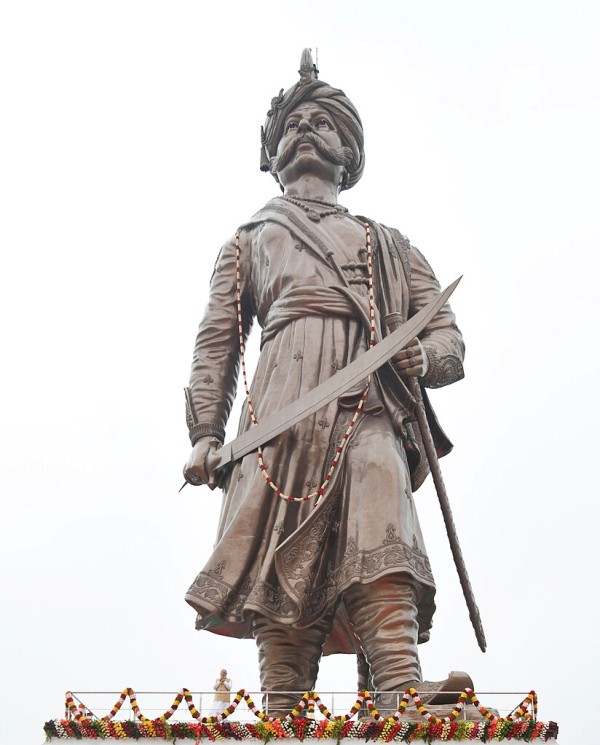 A 33-metre statue of a man dressed in traditional Indian clothing towers over the photographer.